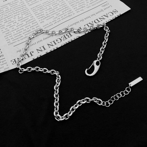 Silver punk hip hop O-chain necklace with lobster clasp and metal tag on magazine background