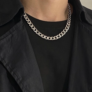 Detailed view of chunky silver Cuban link chain necklace on model with street style