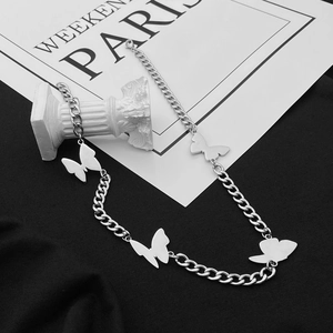Close-up of silver butterfly necklace on vintage column prop with gothic chain details