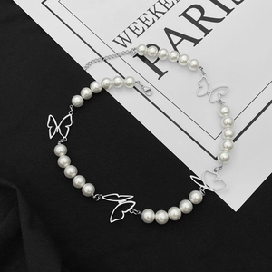 Élégant collier papillon en perles argentées avec chaîne réglable sur un fond noir