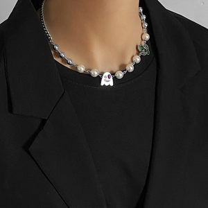 Detail of pearl necklace with ghost and butterfly charms on male model in black suit