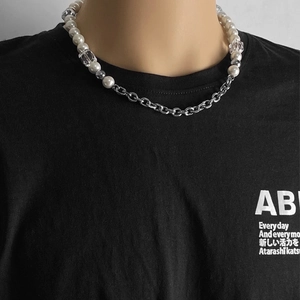 Vista detallada de collar de acero de titanio con perlas blancas y eslabones de metal