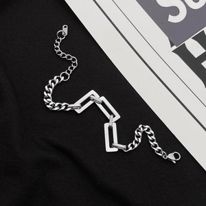 Detail of silver titanium Cuban chain bracelet with rectangular links and K18 tag