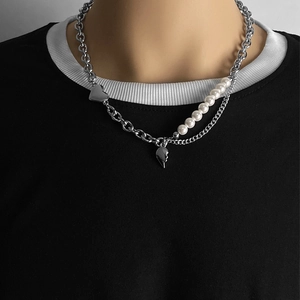 Détail d'un collier multicouche argenté avec breloques cœur et perles sur un mannequin