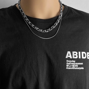 Primo piano di una collana a doppio strato in acciaio inossidabile indossata da un modello