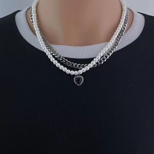 Dettaglio collana a doppio strato in titanio con ciondolo a cuore nero e perle