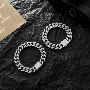 Dettaglio di bracciali a catena cubana in acciaio inossidabile con finitura lucida