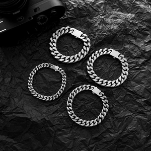 Vista di quattro bracciali a catena cubana in acciaio inossidabile su fondo testurizzato