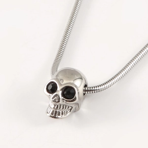 Gothic skull pendant necklace with black gemstone eyes on a silver snake chain
