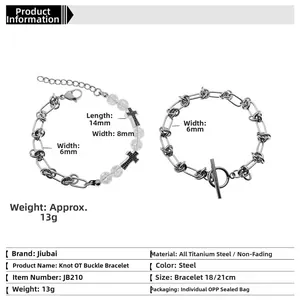 Détail de bracelets en acier titane avec croix et maillons au design industriel
