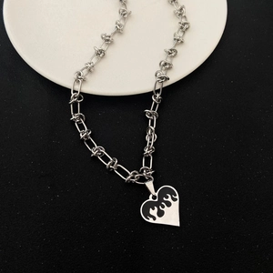 Silver stainless steel heart necklace with black flame pattern on a minimalist plate
