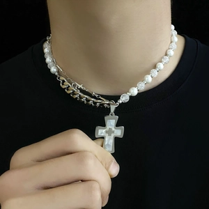 Détail du collier croix multicouche avec perles blanches et chaîne à gros maillons en acier