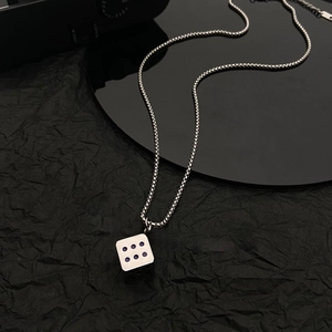Detail of silver titanium steel dice pendant featuring purple dots on round bead chain
