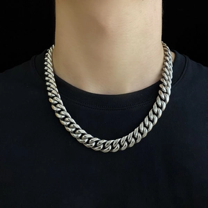 Chaîne cubaine argentée polie style choker pour hommes et femmes sur fond noir minimaliste