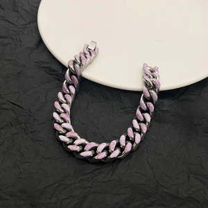Macro detail of silver Cuban link bracelet with purple marble enamel on black background