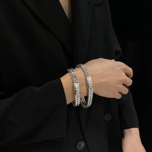 Detail of silver stainless steel woven chain bracelet with a polished magnetic clasp