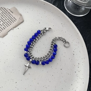 Detail of double-layer bracelet with blue cat eye beads and silver star pendant