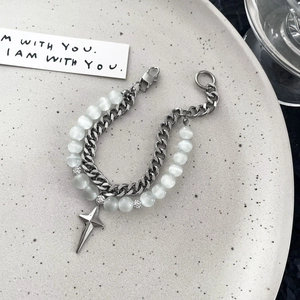 Detail of double-layer bracelet with stainless steel Cuban chain and white cat eye stones