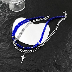 Détail du collier à plusieurs rangs avec perles bleues et chaîne argentée sur miroir
