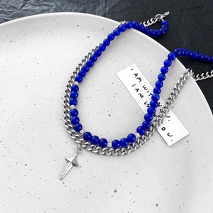 Détail du collier à double couche, chaîne cubaine et perles œil de chat bleu avec étoile