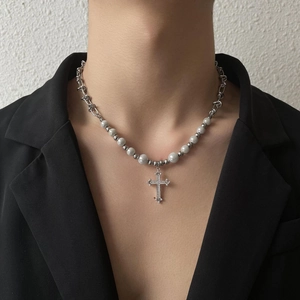 Collier croix chic avec chaînes argentées asymétriques et perles sur mannequin