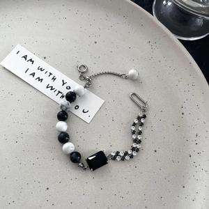 Macro shot of black marble beads and rectangular faceted stone on adjustable chain