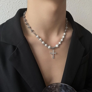 Détail du collier à pendentif croix avec perles réfléchissantes et chaîne argentée