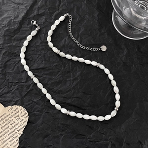 Dettaglio della collana di perle di conchiglia bianche con distanziatori in metallo diamantato