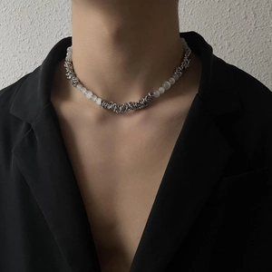 Detail of industrial style necklace with silver metal rings and cat eye stone beads on model
