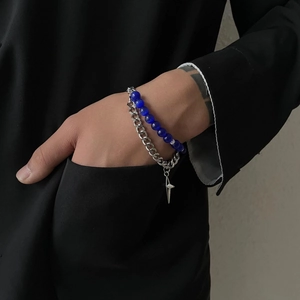 Detail showing blue cat eye beads and silver Cuban chain with a star pendant