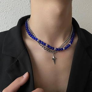 Détail d'un collier double épaisseur avec perles œil de chat bleues et pendentif étoile
