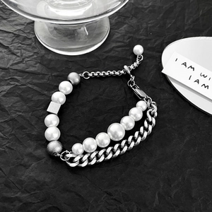 Close-up of double-layered cuban chain and pearl necklace with geometric metal cubes