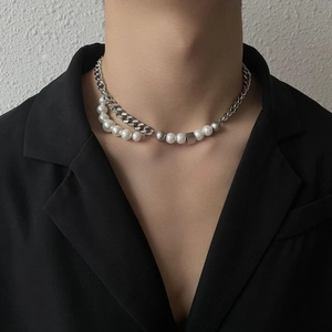 Detail of a punk-style asymmetric Cuban chain necklace with white pearls and silver cubes