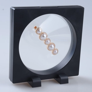 Black 3D floating jewelry box with elegant five-pearl gold hair clip and stable base