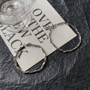 Detail of silver stainless steel Mobius chain with lobster clasp on a dark background