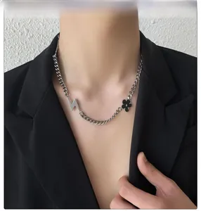 Collier chaîne argenté hip hop avec pendentifs éclair et fleur noire porté par un mannequin