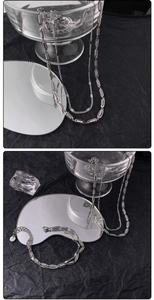 Dettaglio della collana a doppio strato in argento con maglie ovali su sfondo nero