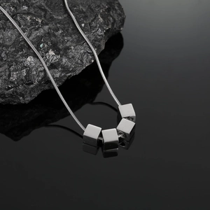 Vue macro d'une chaîne serpent en acier titane argenté avec pendentifs cubes