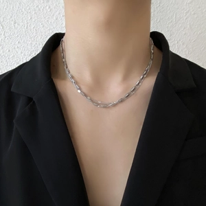 Collana a doppio strato in argento minimalista da uomo indossata su un abito nero