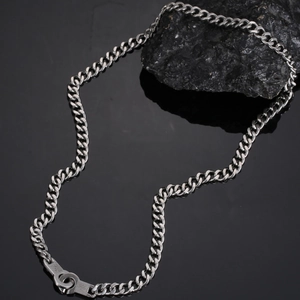 Macro detail of silver Cuban link chain with textured industrial decorative clasp