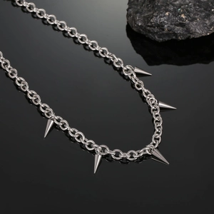 Close-up of high-polish titanium steel punk necklace with five conical metal spikes