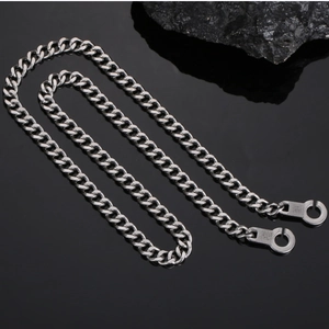 Close-up of silver Cuban link chain featuring two polished round handcuff style clasp detail