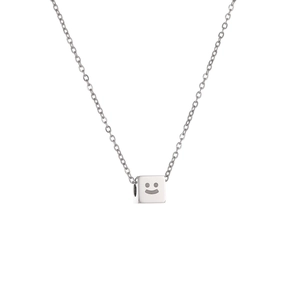 Detail shot of a silver square titanium steel pendant featuring a smile face engraving