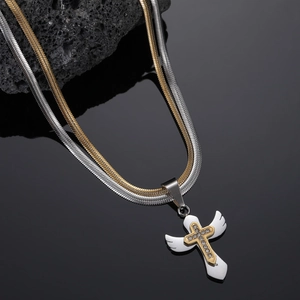 Double-layered snake chain necklace with silver and gold tones and a crystal wing cross pendant