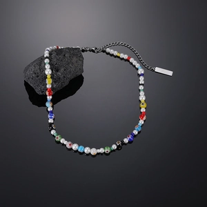 Dettaglio macro di perle colorate in vetro millefiori e perle bianche su una collana