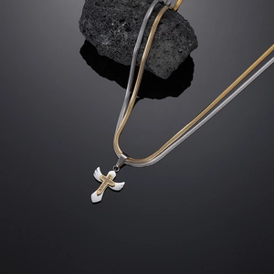 Detail of double-layer snake chain with gold cross and white enamel wings pendant