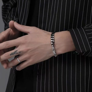 Gros plan d'un bracelet gourmette en acier titane pour homme avec fermoir industriel chic
