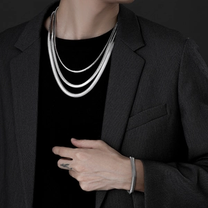 Close-up of triple-layered silver snake chain necklace and bracelet on model