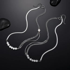 Titanium steel pearl necklace with snake and tank chain design on a black mirror surface