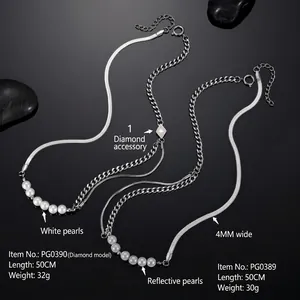 Macro detail of titanium steel necklaces with pearls and silver chain on black pebbles